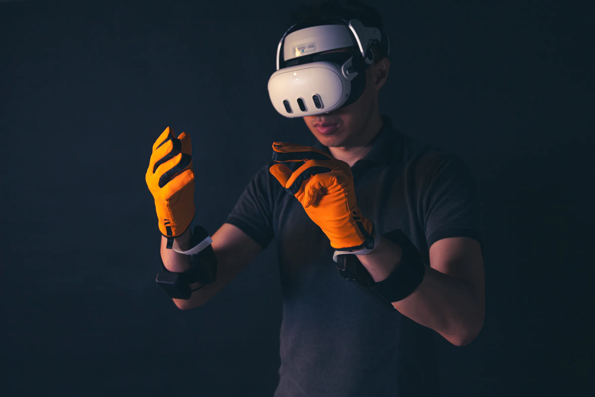 A person in a Quest headset reaching out with both hands in HEXR gloves, hands in clear view of the headset cameras